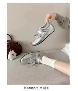 Detailweergave van zilveren satijnen sneakers met klittenband en sleehak voor dames