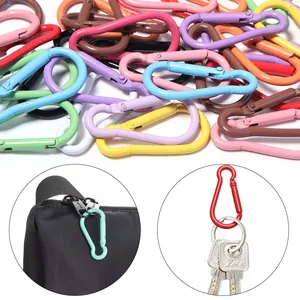 Dettagli sull'uso di moschettoni colorati in alluminio su zaino e anello portachiavi.