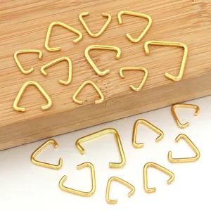 Vista detallada de hebillas triangulares de metal dorado para accesorios de bolsos