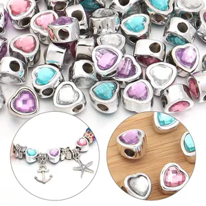 Close-up of heart-shaped large hole beads with colorful faceted resin gems for jewelry making