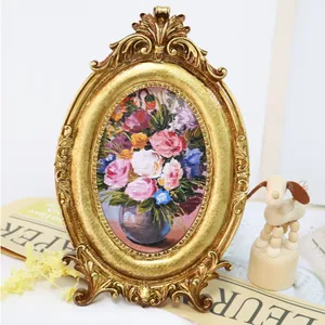 Detailansicht eines verzierten goldenen Vintage-Fotorahmens mit Blumen-Ölgemälde