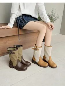 Two-tone patchwork western slouchy boots for women with stylish buckle strap detail.