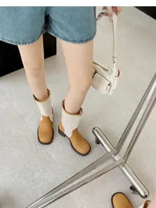 Detail view of two-tone retro cowboy boots with beige patchwork and square toe design