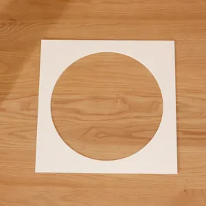Paspartú blanco cuadrado con recorte circular sobre superficie de madera natural