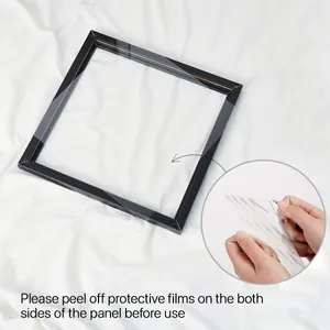 Détail montrant le retrait du film protecteur d'un cadre photo en bois noir carré