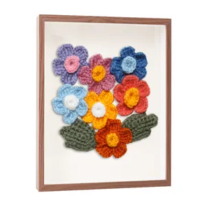 Vue détaillée de fleurs en crochet faites main dans un cadre en bois creux en 3D