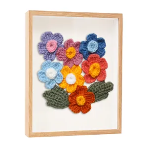 Vue latérale d'un cadre vitrine carré décoré de fleurs colorées faites au crochet