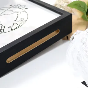 Detalle de la caja de recuerdos de madera negra con asa para boletos y postales