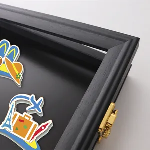 Primo piano di una cornice a bacheca in legno nero con chiusura dorata per le calamite