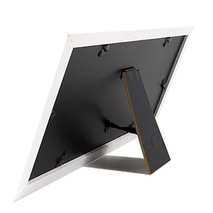 Back view of a white picture frame with a black backboard and a sturdy easel stand.