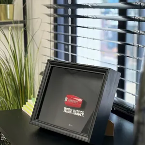 Gros plan du cadre d'affichage 3D noir avec clé de voiture rouge et texte de motivation.