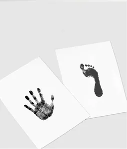 Detailed black ink baby handprint and footprint impressions on white keepsake cards
