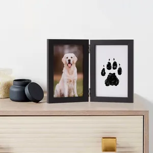 Dettaglio della cornice commemorativa in legno nero con foto di cane e impronta zampa