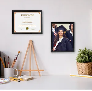 Cadres de diplôme A4 noirs minimalistes fixés au mur au-dessus d'un bureau.