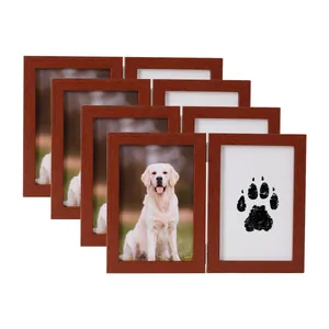 Dettaglio di cornici commemorative per animali in legno bruno-rosso con foto e zampa