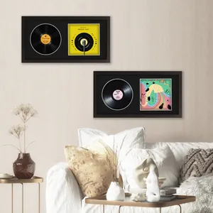 Minimalist black vinyl record and album cover display frames mounted on a beige wall