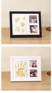 Close-up view of DIY clay handprint and pet pawprint commemorative frames in black and white