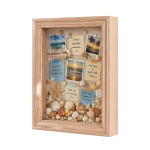 Detalle de un marco 3D de madera con conchas marinas y fotos de playa decorativas.