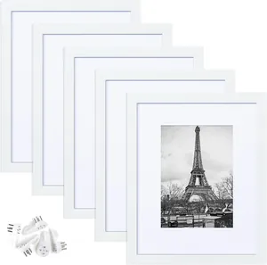 Detailed view of six white PVC picture frames with mounting hooks and white matting