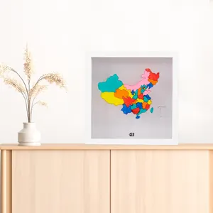 Vue détaillée d'un cadre de mémoire blanc avec une carte colorée sur un meuble en bois.