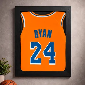 Detail of black wooden frame displaying an orange custom basketball jersey on textured wall