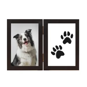 Close-up detail of a wooden hinged double pet memorial photo frame with paw prints