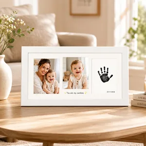 Detailed macro view of white baby handprint photo frame on a wooden table in home