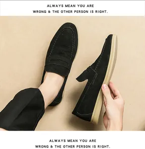 Detail view of men's black suede loafers with minimalist stitching and tan sole.