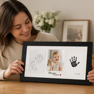 Detail shot of a triple-aperture DIY baby hand and footprint keepsake frame in a home setting
