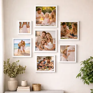 Collection de cadres photo carrés en bois blanc disposés en mur de galerie pour la maison