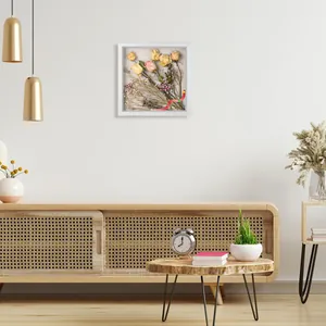 Marco de vitrina blanco con flores secas en un salón de estilo minimalista