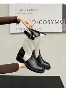 Detail view of retro western boots featuring black leather and canvas patchwork design