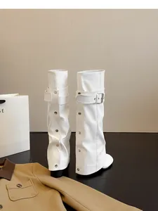 Detailweergave van witte laarzen met brede schacht en zilveren studs en gesp