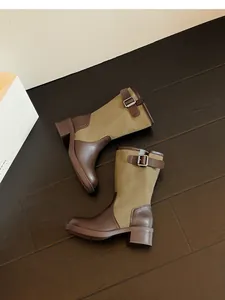 Detail view of vintage brown leather and green canvas patchwork women's knight boots with buckle.