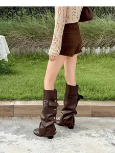 Detail van vintage bruine laarzen met afneembare schacht, gesp en studs details.
