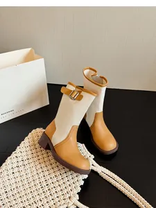 Detailed view of vintage patchwork mid-calf boots with cream canvas and tan leather