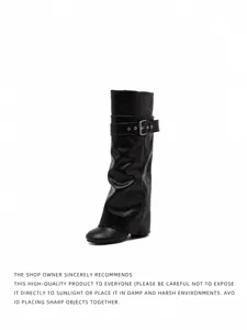 Detailansicht schwarzer kniehoher Stiefel mit Schnallenriemen und weitem Schaft