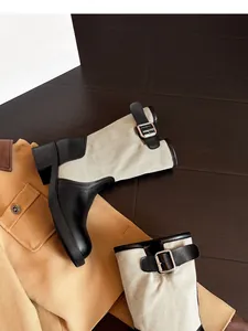Close-up of vintage patchwork cowboy boots with buckle straps and canvas detail