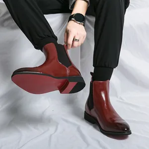 Sophisticated burgundy men's Chelsea boots featuring a pointed toe and a bold red sole design