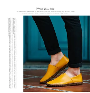 Detail view of yellow leather slip-on loafers for men with decorative hand stitching.