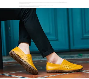 Detailed side view of yellow leather loafers with perforated patterns and hand-stitched rubber soles.