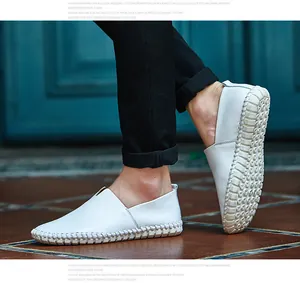 Detailed view of men's white top grain leather slip-on loafers with decorative hand-stitching.