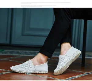 Detail view of men's white perforated leather slip-on loafers with thick stitching