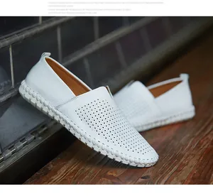 Detailed close-up of white perforated cowhide leather slip-on loafers with rubber sole