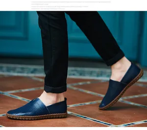 Side view of navy blue leather loafers with perforated details and hand-stitched soles.