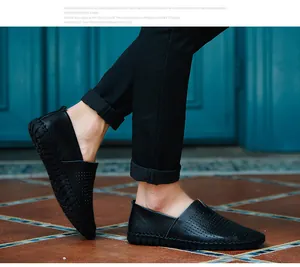 Close-up detail showing black leather loafers with a breathable perforated design.