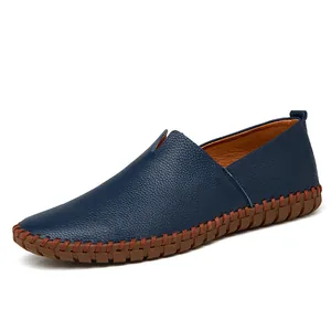 Dark blue pebbled leather men's slip-on loafers featuring a durable brown stitched sole