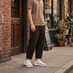 Lifestyle-detail van beige German Army Trainer sneakers gecombineerd met een bruine broek.