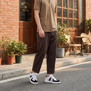 Stijlvolle man met zwart-witte German Army Trainer sneakers in een stedelijke buitenomgeving