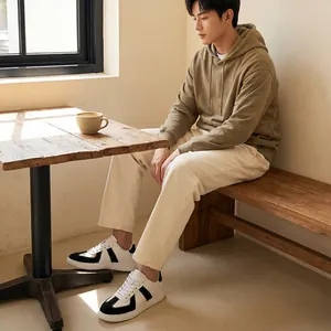 Lifestyle-foto van een man met zwart-witte GAT-sneakers in een rustige café-omgeving